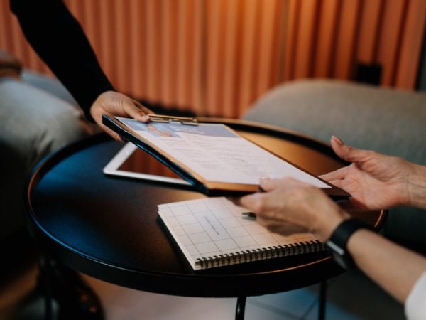 Recruiters and staffing professionals collaborating at a table with a clipboard.