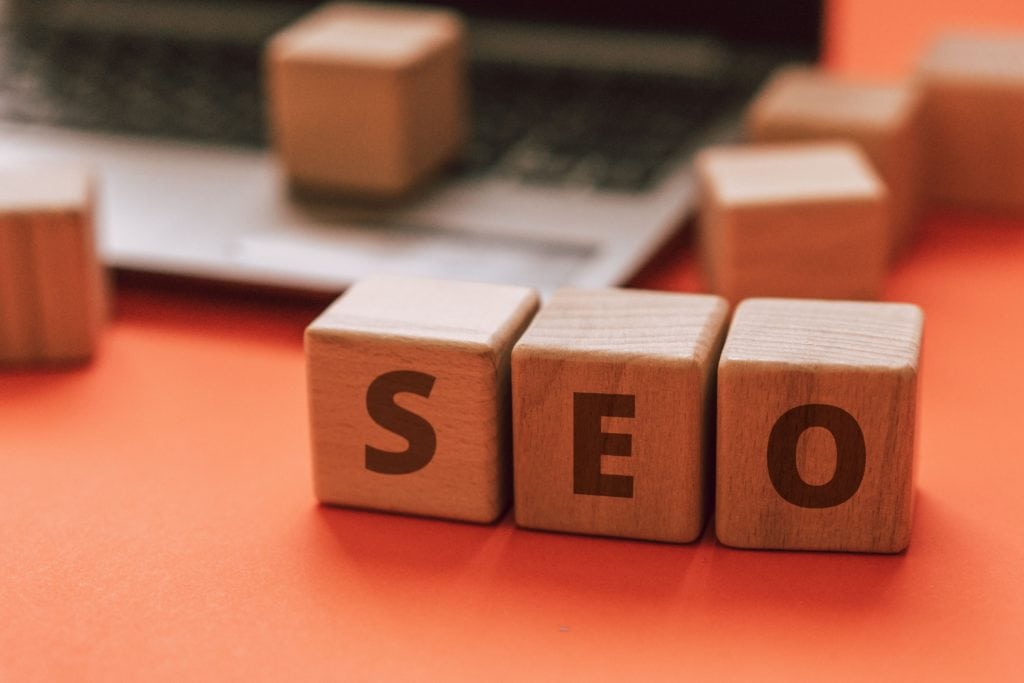 The word seo spelled out on wooden blocks next to a laptop, highlighting its relevance for nonprofits.