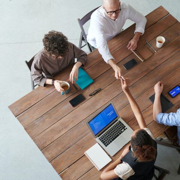 A group of people at a table exchanging high fives during a website redesign meeting in Chicago.