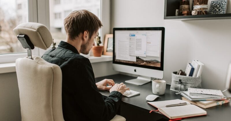 A man applying the Magic Marketing Equation while working at his desk in front of a window.