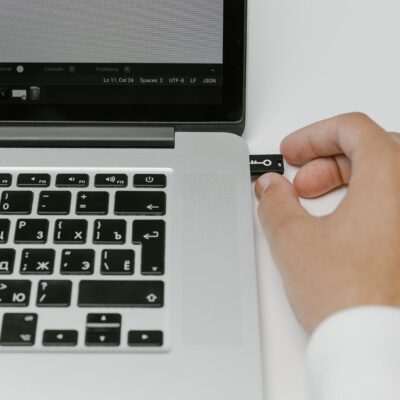 A person holding a laptop connected to a mouse.