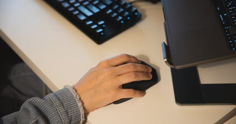 A person's hand on a computer mouse exploring Keywords 101 in Digital Marketing.